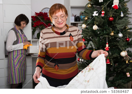 Mature mother with adult daughter getting ready to celebrate the New Year Mature mother with adult daughter getting ready to celebrate the New Year 58368487