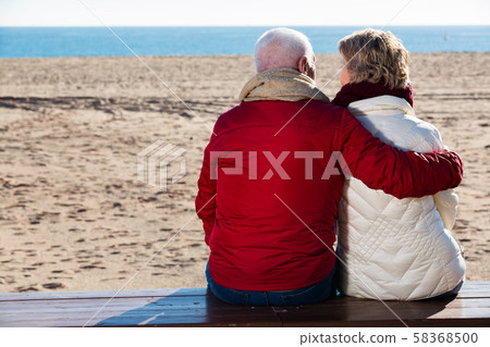 Mature couple sitting by sea 58368500