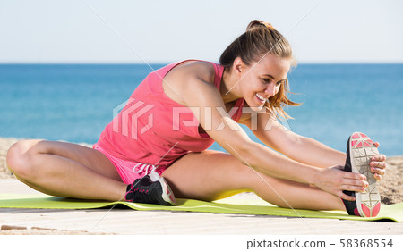 Cheerful young sportwoman workout at sea beach Cheerful young sportwoman workout at sea beach 58368554