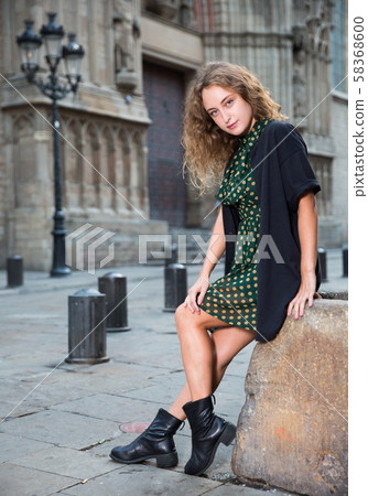 Young attractive woman tourist sitting at stone in historical center Young attractive woman tourist sitting at stone in historical center 58368600