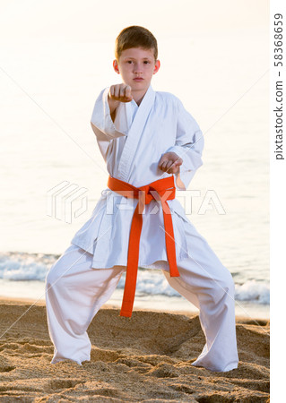 Boy doing karate at ocean quay Boy doing karate at ocean quay 58368659
