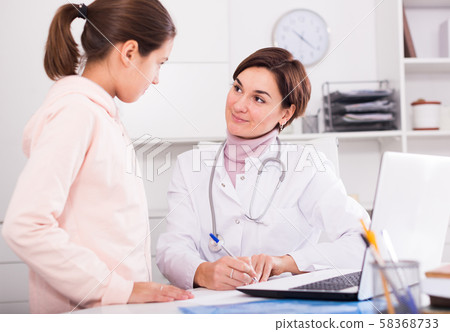 Doctor fills patient card for girl Doctor fills patient card for girl 58368733
