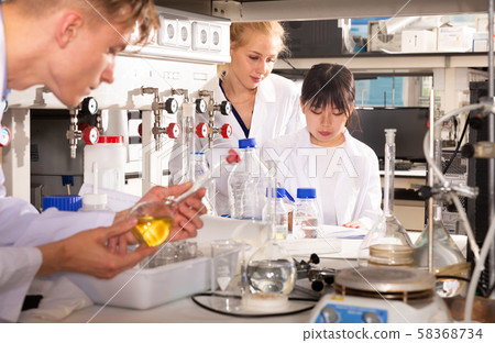 Scientists in white coats working at laboratory Scientists in white coats working at laboratory 58368734