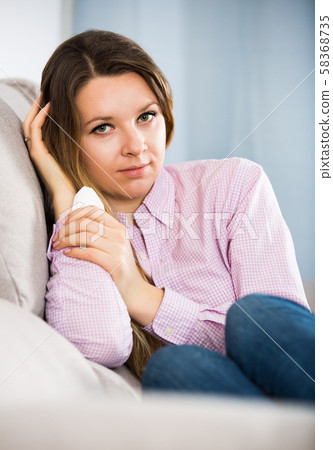 Sad young woman spending day alone indoors Sad young woman spending day alone indoors 58368735