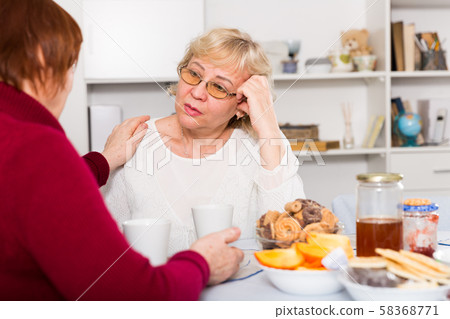 Mature lady comforting upset female Mature lady comforting upset female 58368771