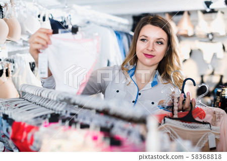 Customer choosing pretty lingerie in underwear shop 58368818