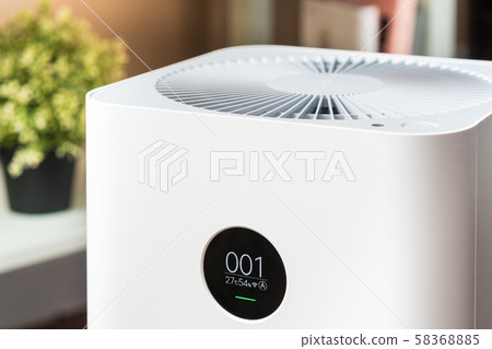 Closeup of an indoor Air purifier with monitor screen that show air quality in the room is very safe and clean to breathe while dust air pollution situation outside is really bad. PM 2.5, Healthy. 58368885