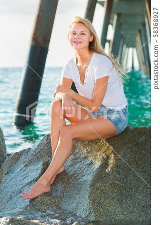 Female is posing on the rocks in her free time 58368927