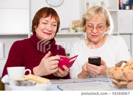 pensioners females holding mobile phones pensioners females holding mobile phones 58369067