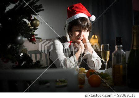 Upset girl at the holiday table on Christmas night Upset girl at the holiday table on Christmas night 58369115