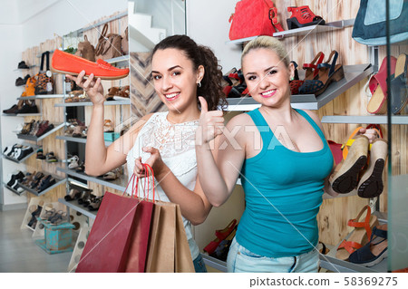 Two girls holding a paper shopping bags in the boutique 58369275