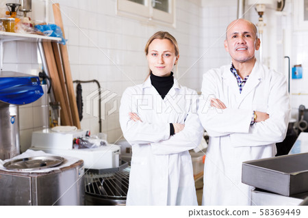 Different aged people standing in production workshop Different aged people standing in production workshop 58369449