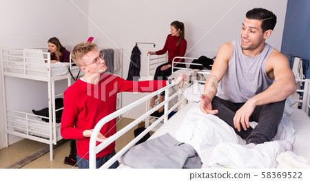 Male tourists communicating in hostel Male tourists communicating in hostel 58369522