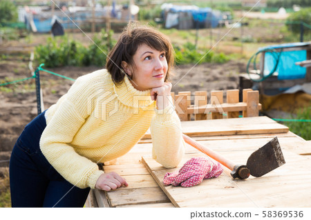 Girl in a yellow sweater in the backyard of her cottage Girl in a yellow sweater in the backyard of her cottage 58369536