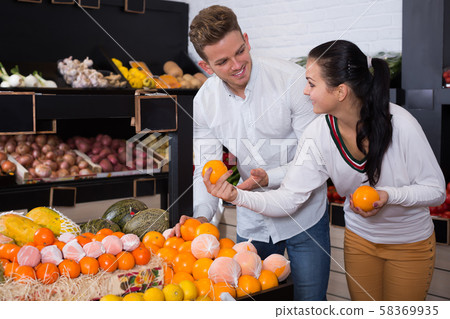Loving couple deciding on fruits in shop Loving couple deciding on fruits in shop 58369935