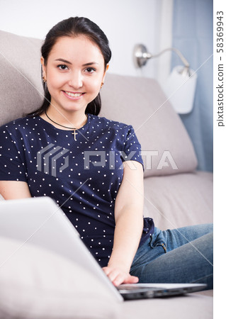 Young woman with laptop on sofa Young woman with laptop on sofa 58369943
