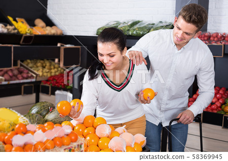 Couple of buyers examining various fruits 58369945