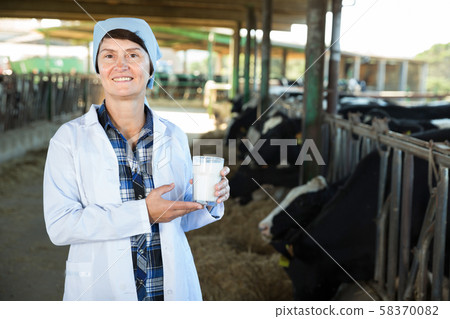 Female farmer in white robe with milk Female farmer in white robe with milk 58370082