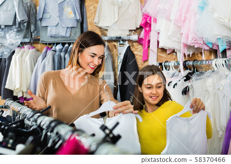 Mother and daughter choosing pretty dress Mother and daughter choosing pretty dress 58370466