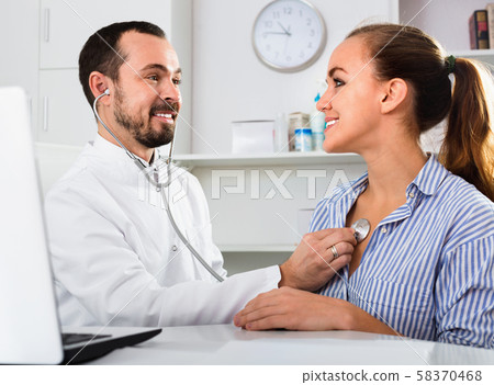 Female visitor consulting man doctor in hospital Female visitor consulting man doctor in hospital 58370468