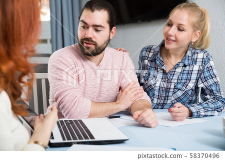 Smiling young woman with husband and mother with financial documents Smiling young woman with husband and mother with financial documents 58370496