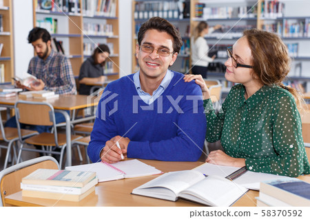 Female and male students working in library Female and male students working in library 58370592
