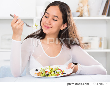young woman eating freshness salad 58370696