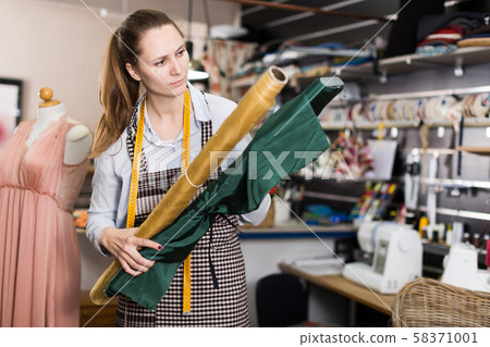 Portrait of woman designer who is choosing new colors of fabric for dress Portrait of woman designer who is choosing new colors of fabric for dress 58371001