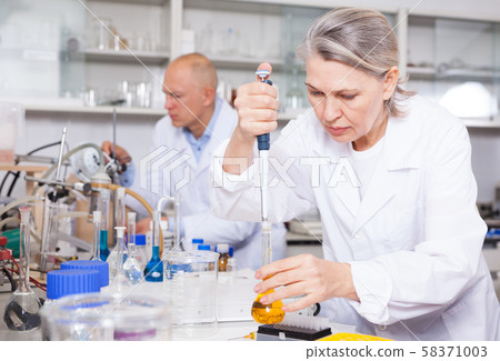 Female scientist working with reagents Female scientist working with reagents 58371003