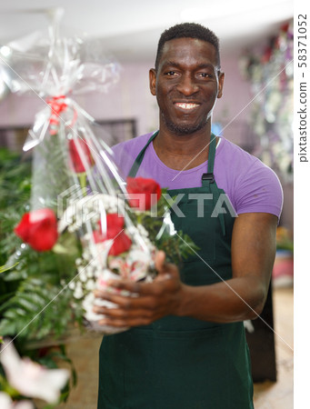 Florist offering flower arrangements Florist offering flower arrangements 58371052