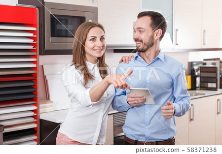 Couple talking in kitchen furnishing store Couple talking in kitchen furnishing store 58371238