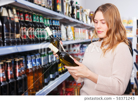 Female buying bottle of wine Female buying bottle of wine 58371243