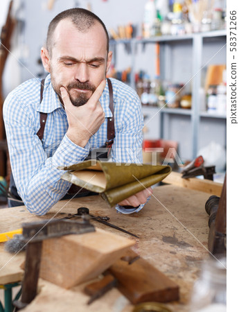 Annoyed workman in repair furniture workshop 58371266