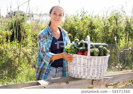Female gardener posing with harvest 58371388