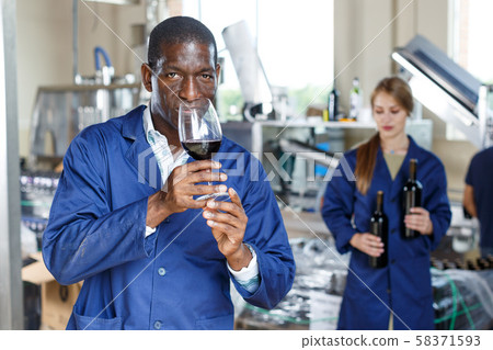 Winery worker testing new wine Winery worker testing new wine 58371593