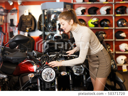 Woman choosing new motorbike 58371720