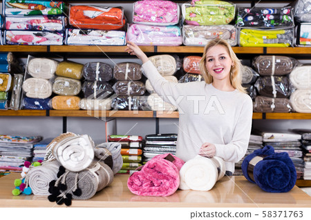 Smiling young seller is showing plaids 58371763