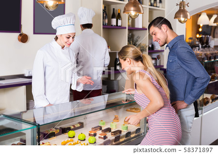 Smiling woman is serving visitors Smiling woman is serving visitors 58371897