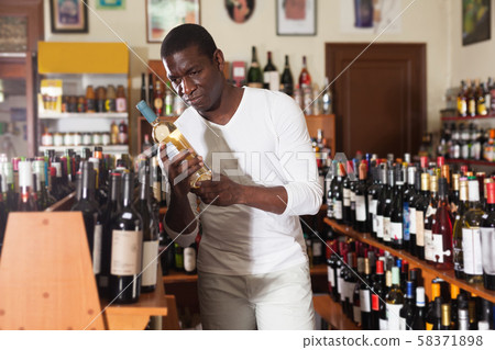 Man choosing wine in store Man choosing wine in store 58371898