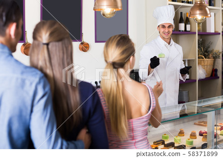 Cheerful chef man is serving visitors Cheerful chef man is serving visitors 58371899