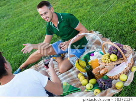 Man enjoying life on picnic outdoors with his friend 58372124