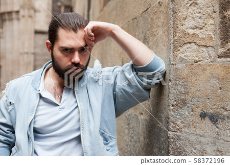 Handsome bearded man walking along old town street Handsome bearded man walking along old town street 58372196