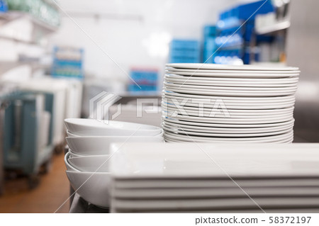 Closeup of clean plates in restaurant kitchen Closeup of clean plates in restaurant kitchen 58372197
