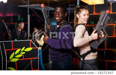 Two nice laser tag players standing back to back 58372347