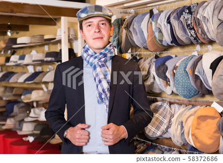 portrait of young male try on newboy cap at the shopping mall 58372686