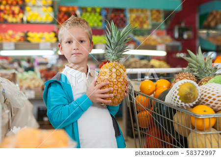 Kid holding big pineapple 58372997