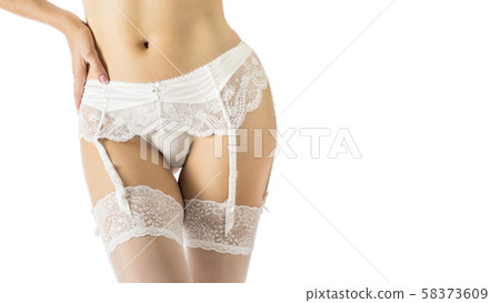 Female hips in white bridal garter belt, fishnet stockings and lace panties. Close up, isolated on 58373609