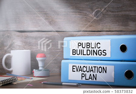 Evacuation plan and public buildings. Two binders on desk in the office. Work and fire safety concept Evacuation plan and public buildings. Two binders on desk in the office. Work and fire safety concept 58373832