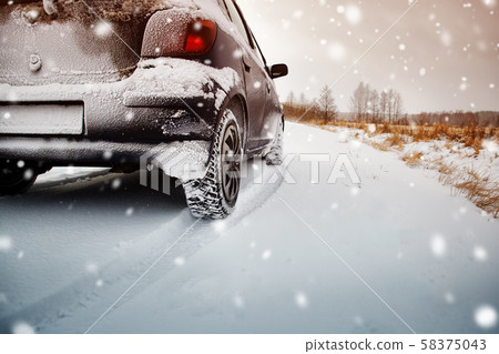 Car tires on winter road covered with snow 58375043