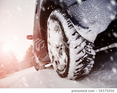 Car tires on winter road covered with snow Car tires on winter road covered with snow 58375050